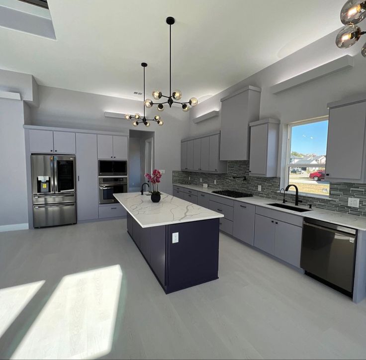 Kitchen renovation with navy island and marble waterfall countertop in Toronto