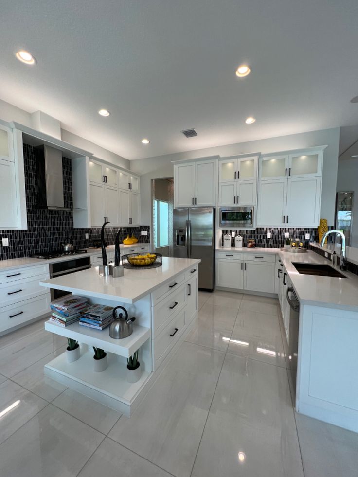 White shaker condo kitchen with quartz island and dark tile backsplash in downtown Toronto
