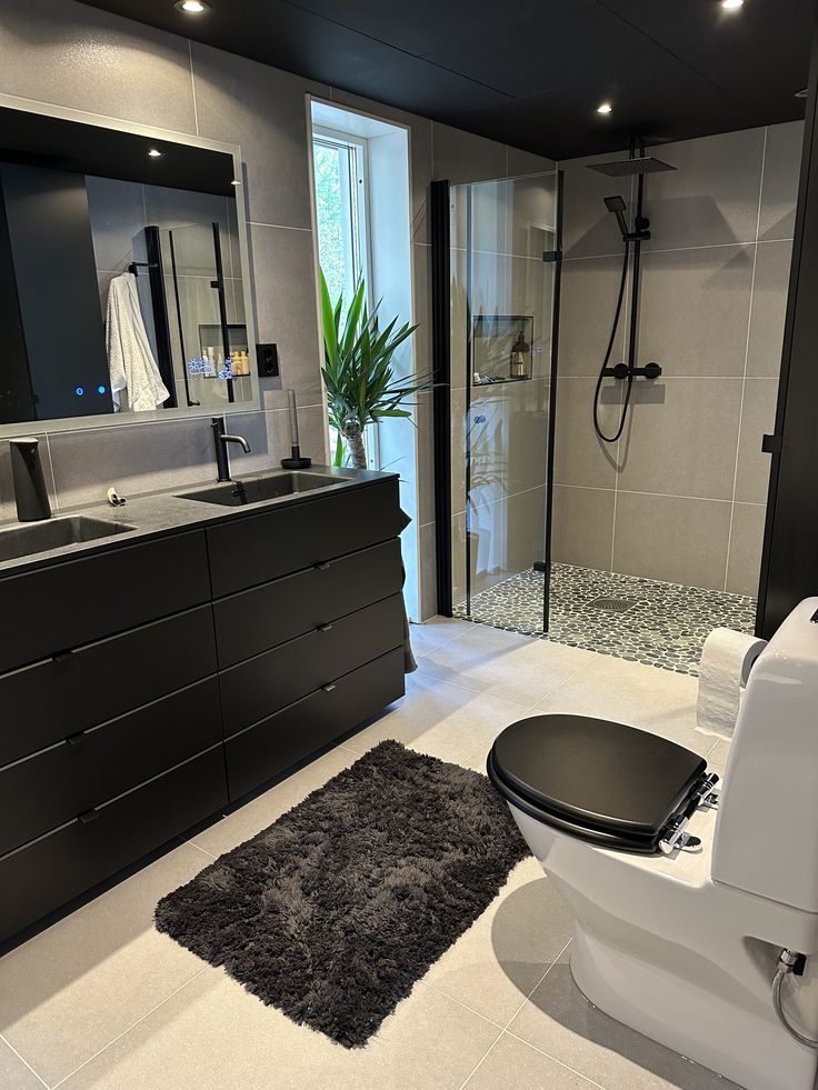 Modern bathroom with floating black vanity and walk-in shower in an Etobicoke home
